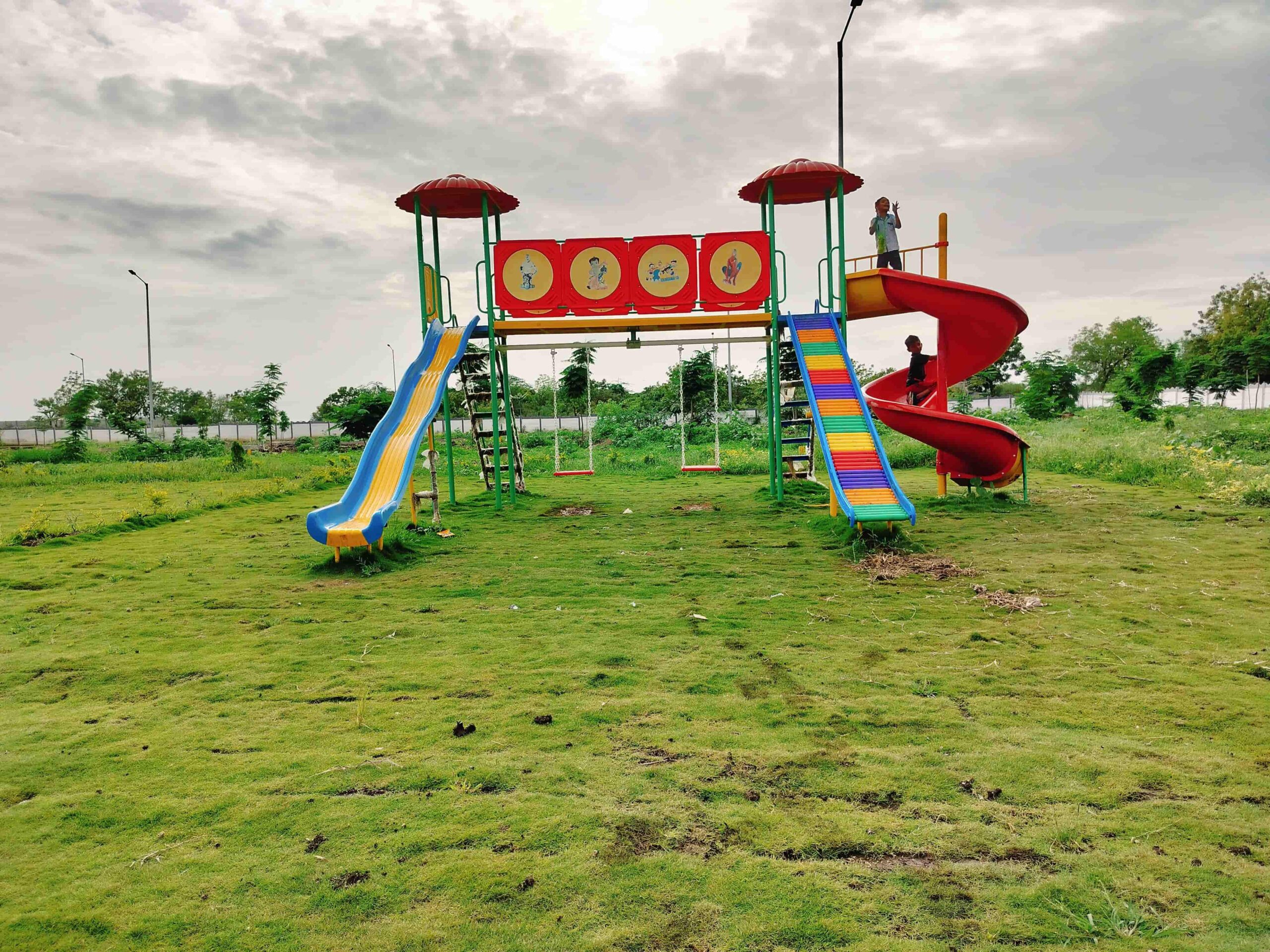A colorful playground with a slide and swings at Venkateshwara City in Vasant Vihar, Solapur.
